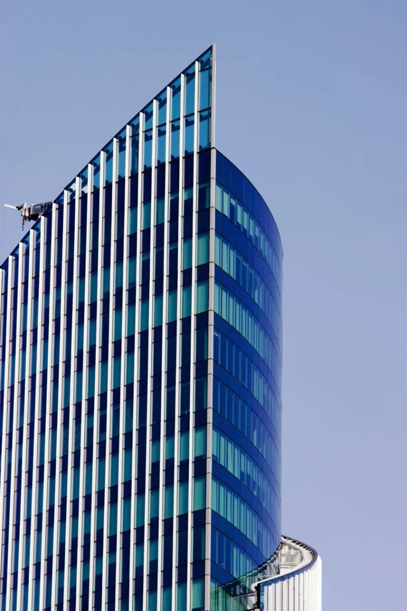 A blue glass office tower seen from below